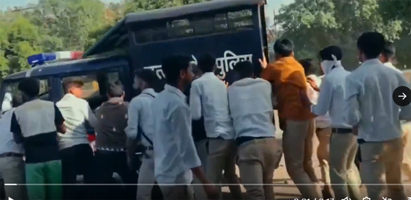 Workers pushing police vehicle out of way
